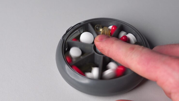 Person use finger to push plastic vitamin pill container button, change sections