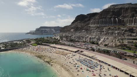 Preciosa-Playa-Con-Bañistas-Y-Sombrillas-Por-Todas-Partes,-Verano-Caluroso