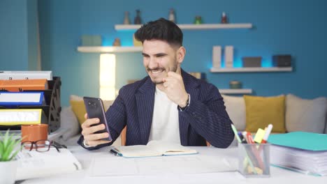 Trabajador-De-Oficina-En-Casa-Mirando-El-Teléfono-Y-Regocijándose-En-Casa.