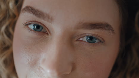woman open blue eyes looking camera macro closeup. serene girl with focused gaze