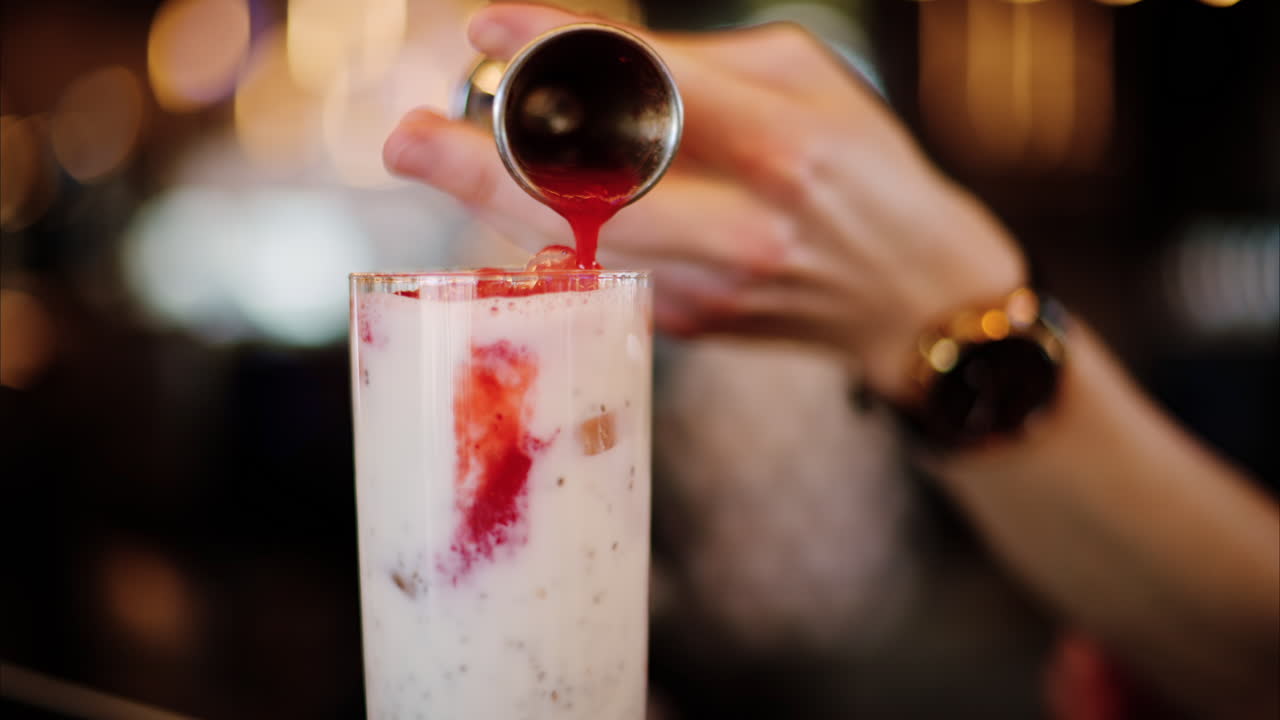 Man pouring strawberry puree in a drink