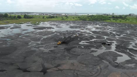 wide drone view of workers mining on the pitch lake in trinidad