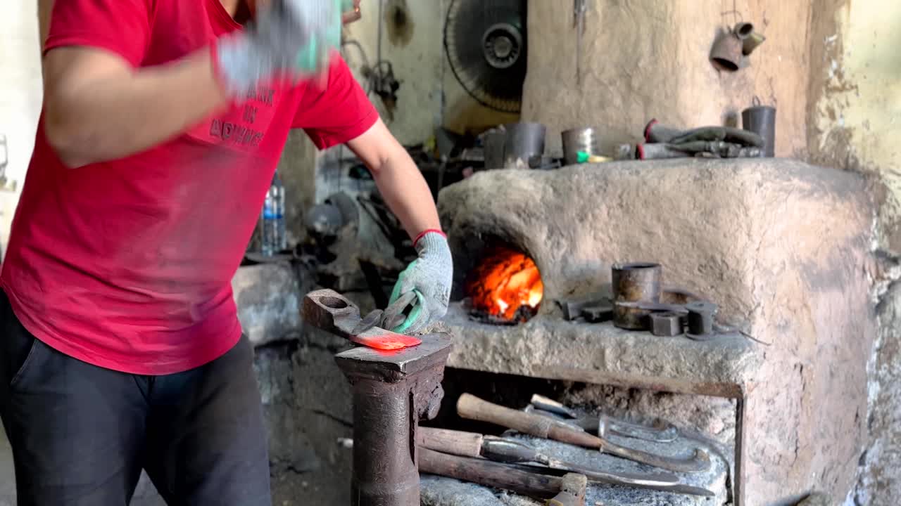 golpear un metal fundido herramientas de agricultura con martillo para hacer un hacha para usar en la jardinería en la granja tierra de cultivo por el agricultor en la temporada de cosecha preparar el campo el trabajador de metal calentarlo en el horno para derretir