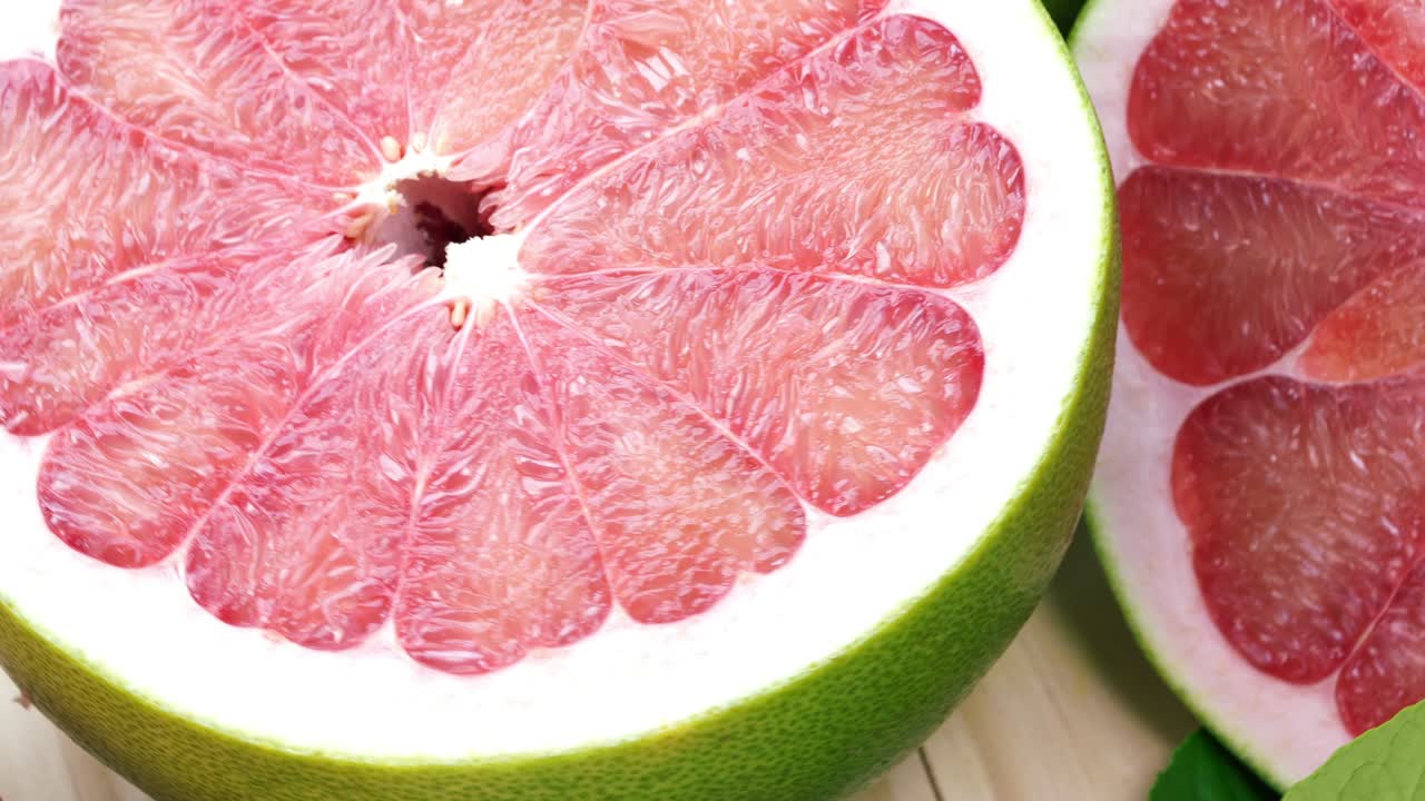 정원에서 나무 테이블에 잎을 가진 빨간 포멜로 과일을 회전, 나무 배경 4k 해상도에서 잎과 함께 빨간 포মেল로 과일.