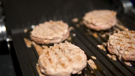 close up slider shot of meat burger cutlet on hot grill pan