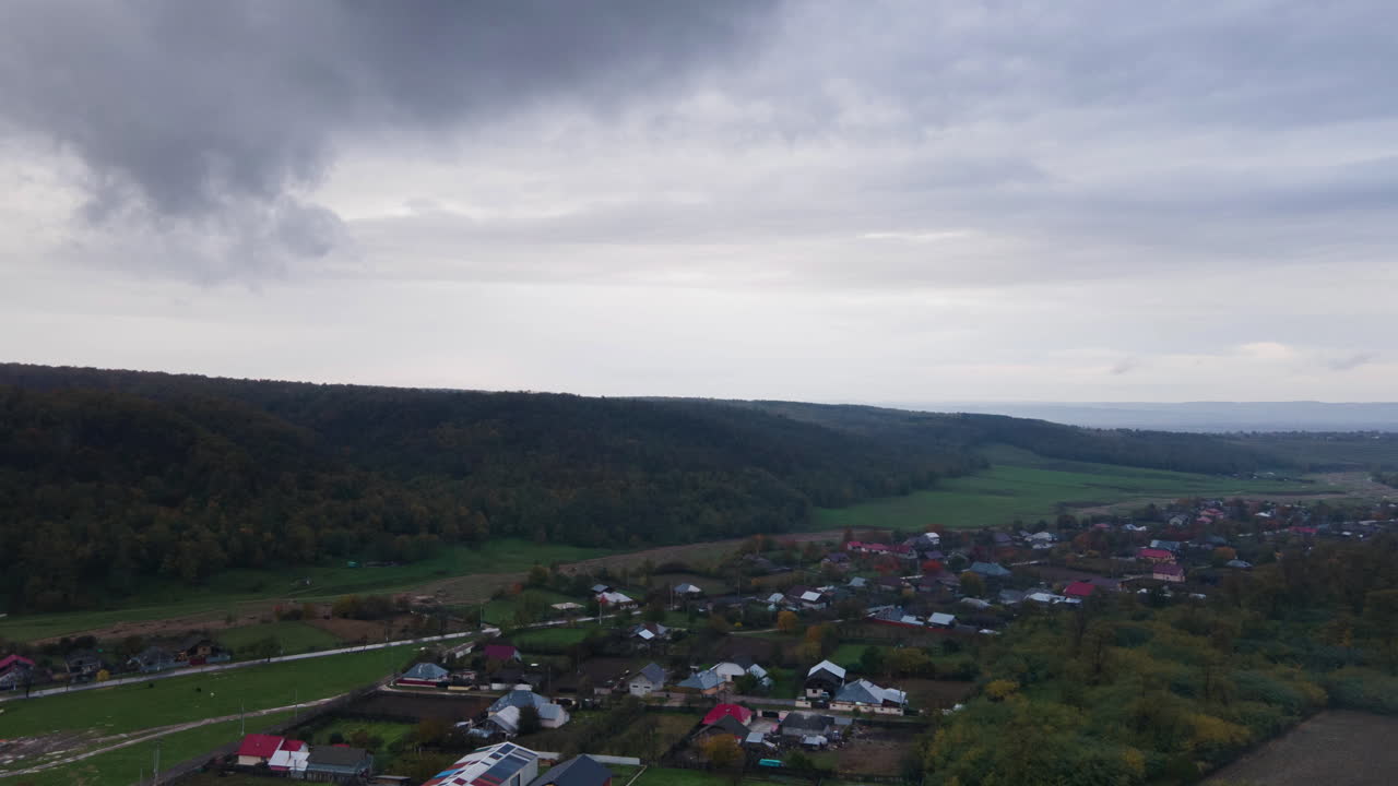 Hyper-lapse under lave regnskyer over en lille landlig bjerglandsby før storm