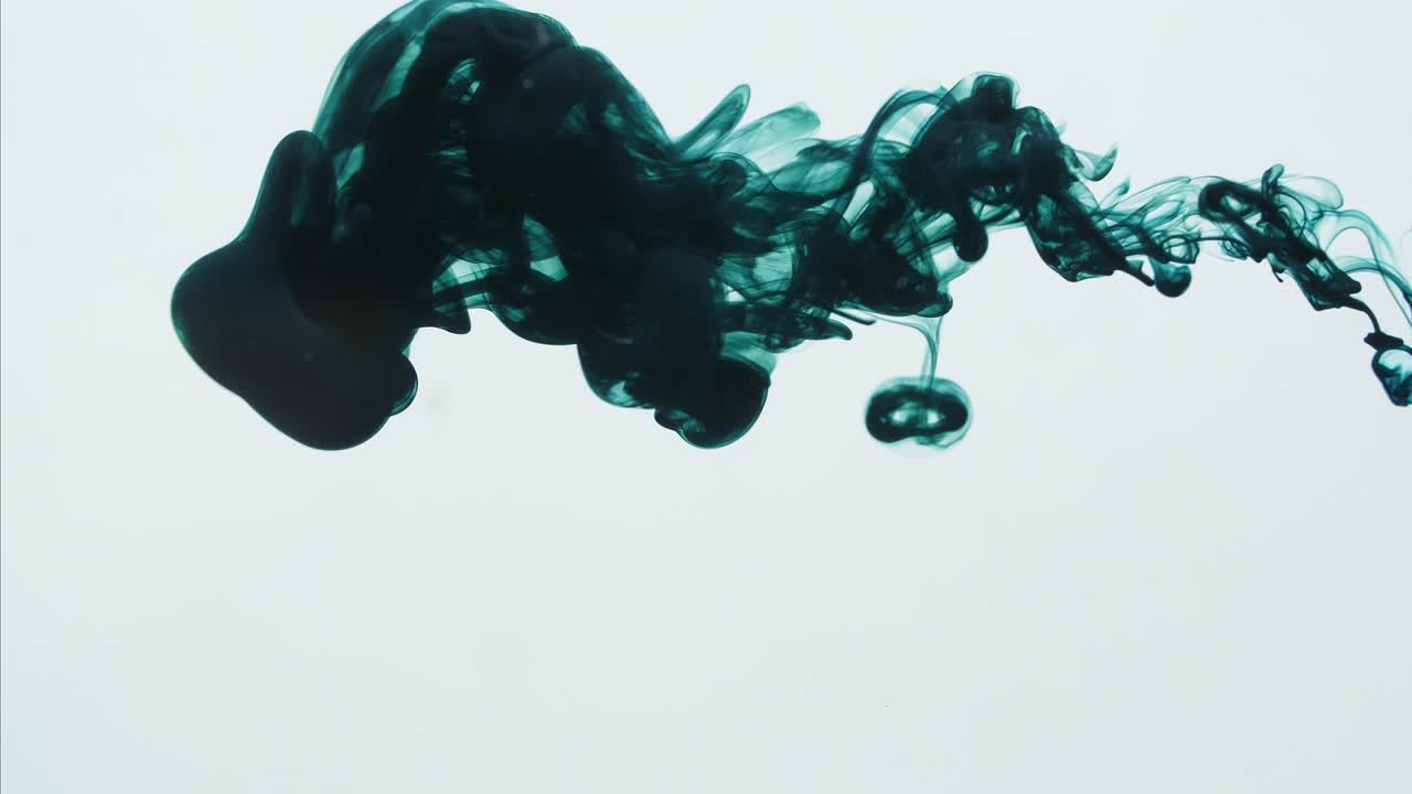 Dark Green Ink Sprayed Into Water On A White Background