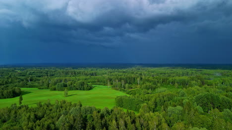 Extremely-dangerous-storm-above-green-forest-landscape,-aerial-drone-view