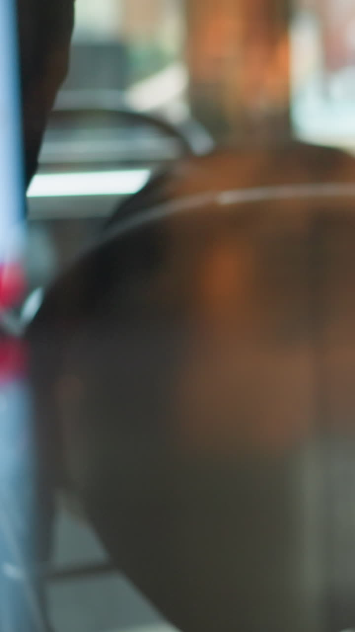 primer plano de las ruedas del carrito de compras en movimiento en la tienda minorista, capturado a través de una ventana borrosa con reflejos, transmitiendo una experiencia de compra ocupada, con el reflejo de alguien en el vidrio