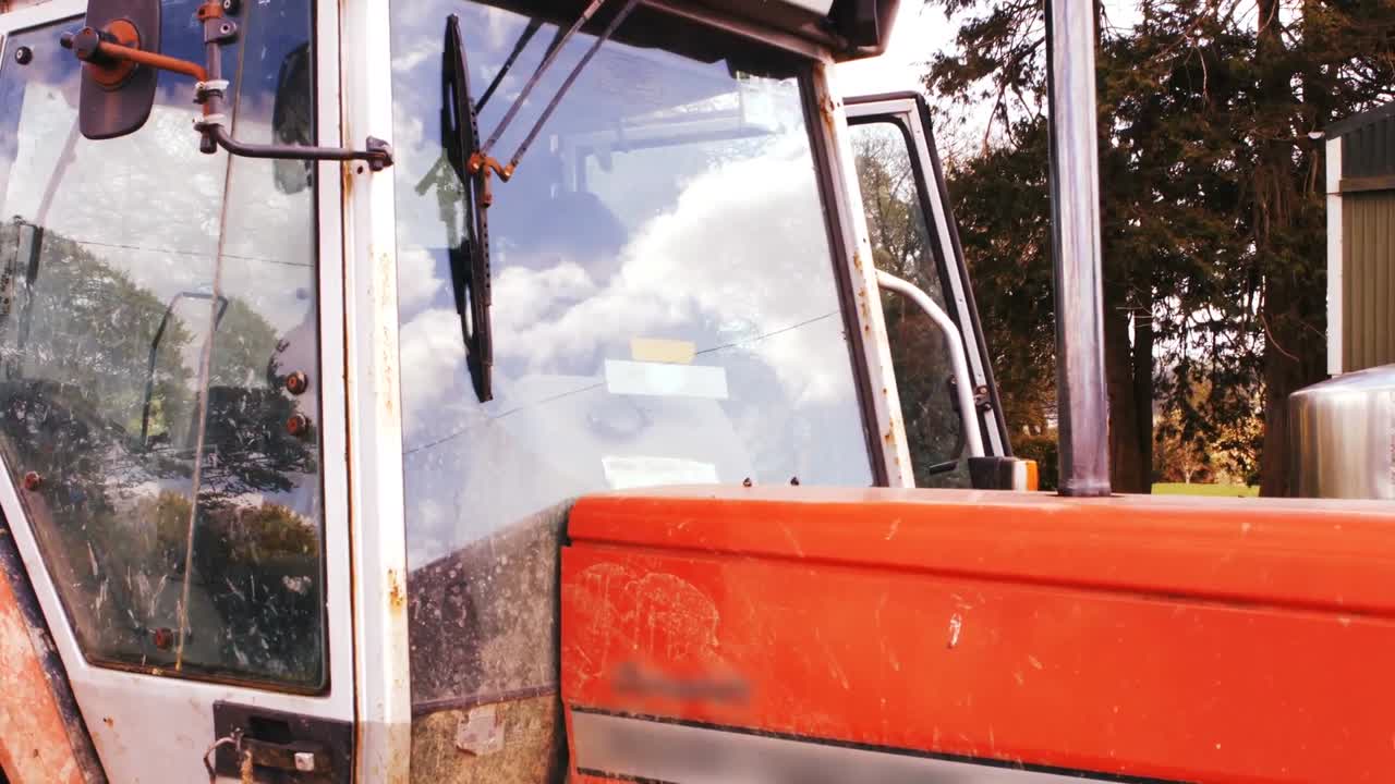 granjero de ganado subiendo al tractor