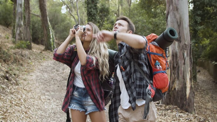 Mochileros con cámara de fotos fotografiando el bosque