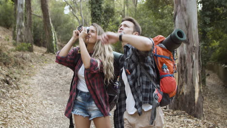 Backpackers-with-photo-camera-taking-pictures-of-forest