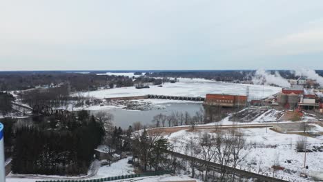 Aéreo,-Torre-De-Agua-De-Stevens-Point-Durante-La-Temporada-De-Invierno,-Río-Wisconsin-Congelado