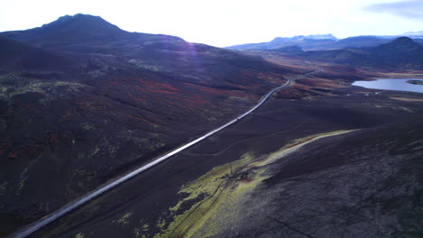 car driving a road in iceland through colorful volcanoes