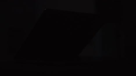 cinematic footage of an apple m1 macbook pro 14 inch being showed with a moving light filmed at a tight focal length in 4k in slow motion shot in the studio with controlled light