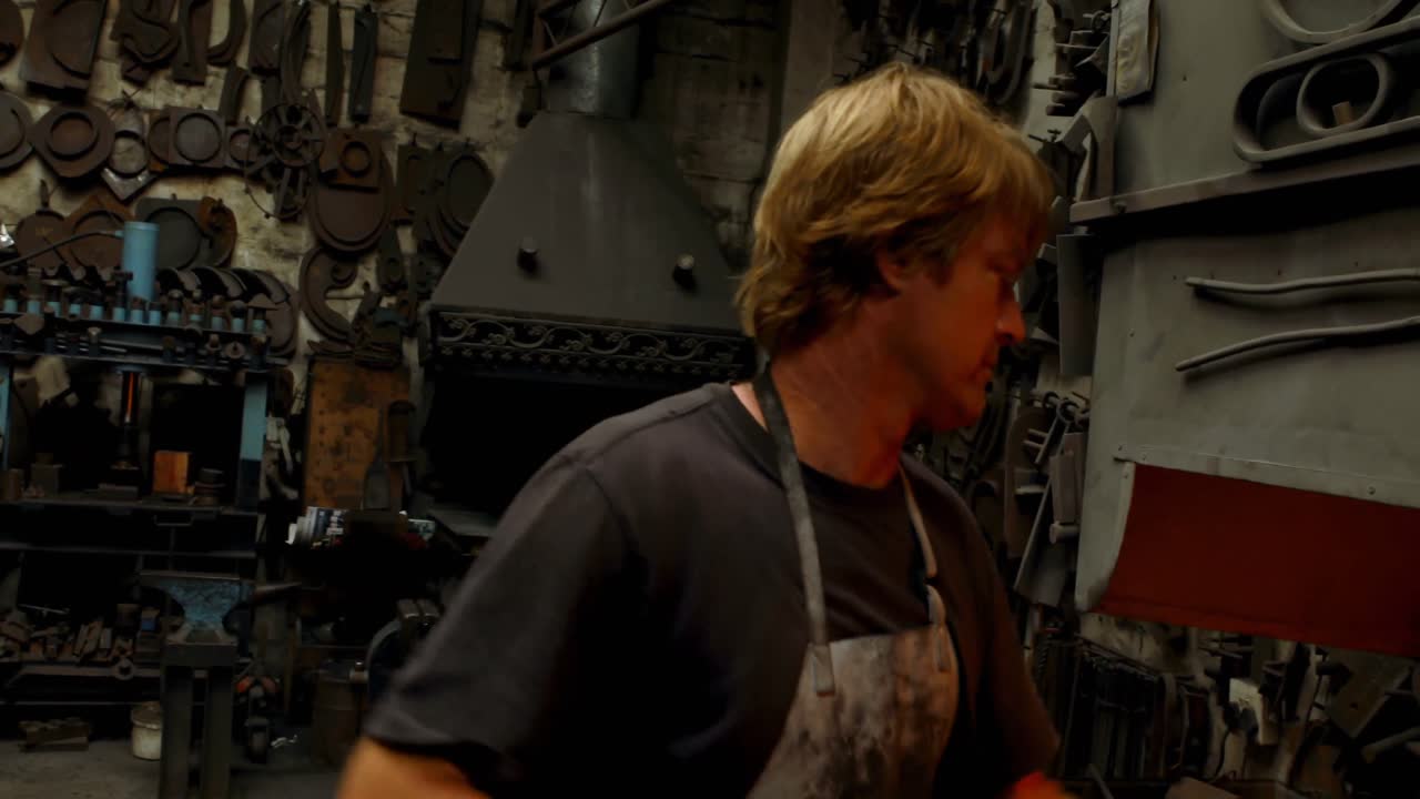 Blacksmith heating metal rod in fire 4k