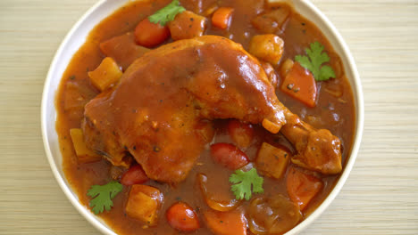 estofado de pollo casero con tomates, cebollas, zanahorias y patatas en un plato con arroz