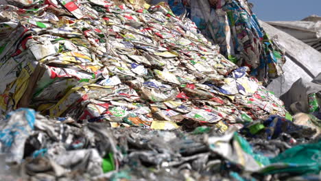 cinematic shot of bales of flattened milk and juice cartons in recycling plant