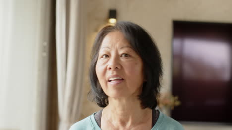 senior asian woman at home with decorations, smiling warmly and celebrating