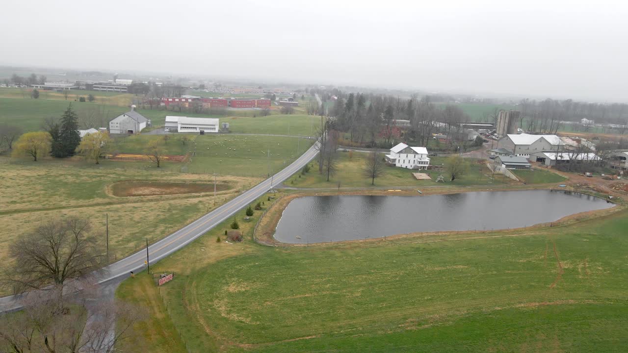 펜실베니아의 작은 호수나 저수지 옆에 있는 농지와 농가의 드론 샷