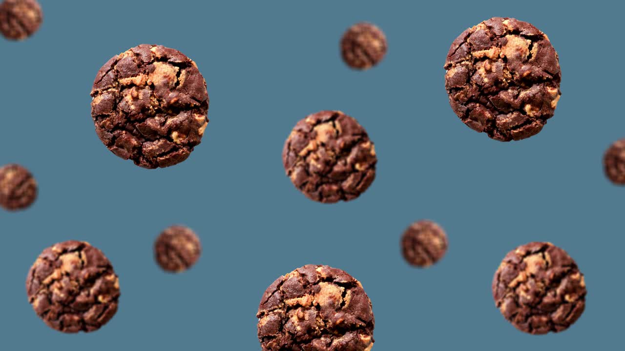다양한 지름의 맛있는 초콜릿  쿠키가 4k uhd 영상에서 트렌딩 파란색 배경 (평면, 루프 할 수 없습니다) 의 중앙으로 이동합니다.