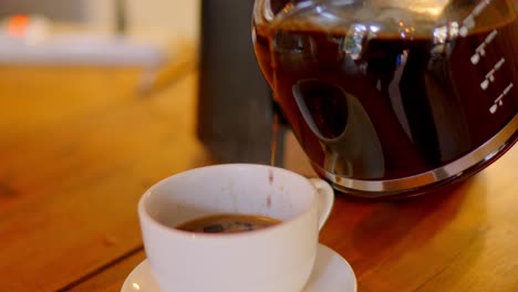 gourmet-coffee-beans-prepared-in-a-coffee-pot-being-served-in-a-white-cup