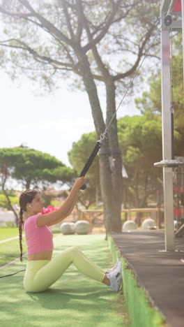 a woman performing seated cable rows at an outdoor gym