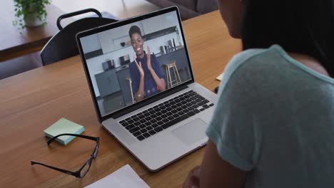 Mid-section-of-african-american-woman-having-a-video-call-with-female-colleague-on-laptop