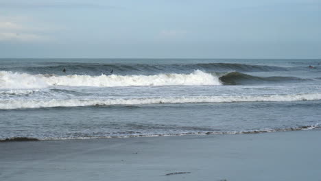 surfistas preparándose para atrapar las grandes olas rompiendo en la orilla