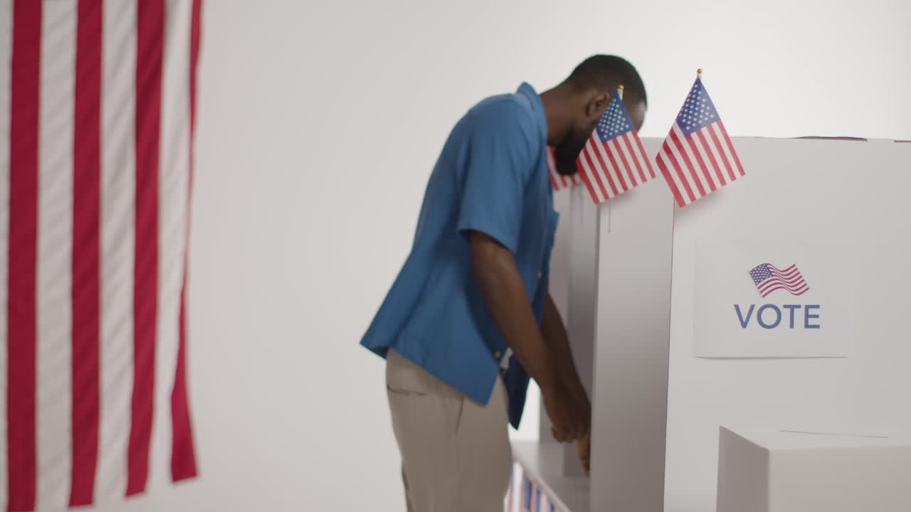 votantes en cabinas con papeletas de votación emitiendo votos en las elecciones estadounidenses 1