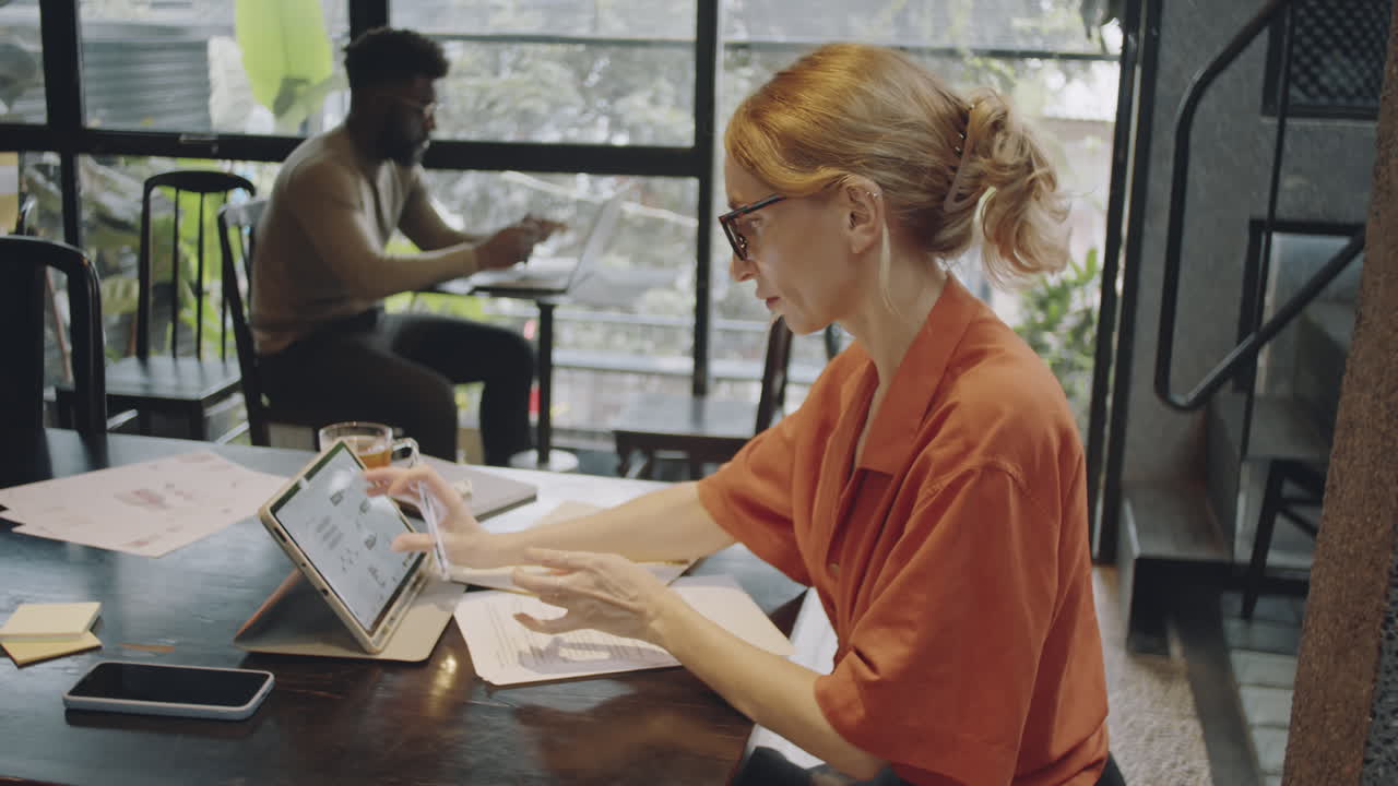 Forretningskvinde arbejder på tablet på en café