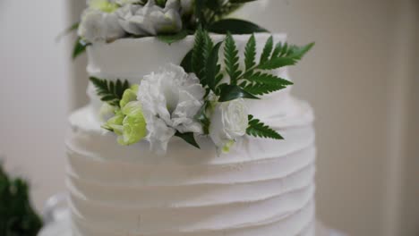 Hochzeitstorte-Mit-Weißem-Zuckerguss-Und-Blumenarrangement-Dekor---Nahaufnahme