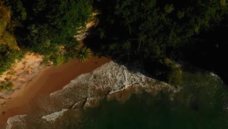 Drone-footage-of-a-scenic-beach-with-crashing-waves-against-a-cliff