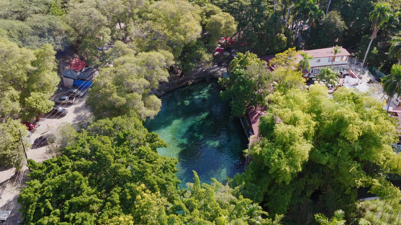 Las Marias natural pool, resort nestled among trees, Neiba in Dominican Republic. Aerial top-down orbiting