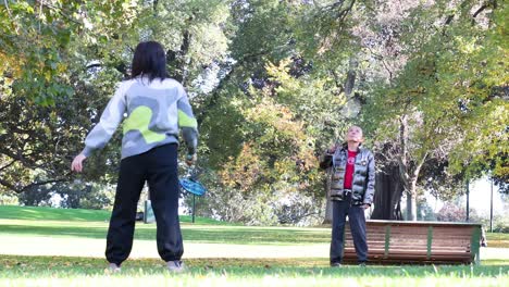 two people enjoying badminton in a park