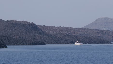 Boot-Segeln-In-Der-Nähe-Von-Vulkangestein-Und-Heißen-Quellen-In-Fira,-Santorini,-Griechenland