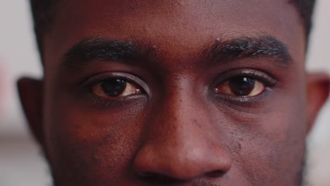 close-up macro portrait of beauty young african american man's eyes, smiling model looking at camera