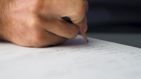 Close-up-shot-of-man-hands-noting-something-in-the-note-book-while-working-in-the-modern-office