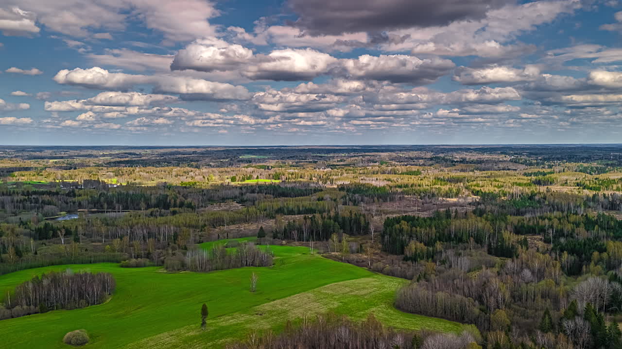 Mesmerizing cloudscape time lapse above forests and fields high above Europe's colorful, rural landscape