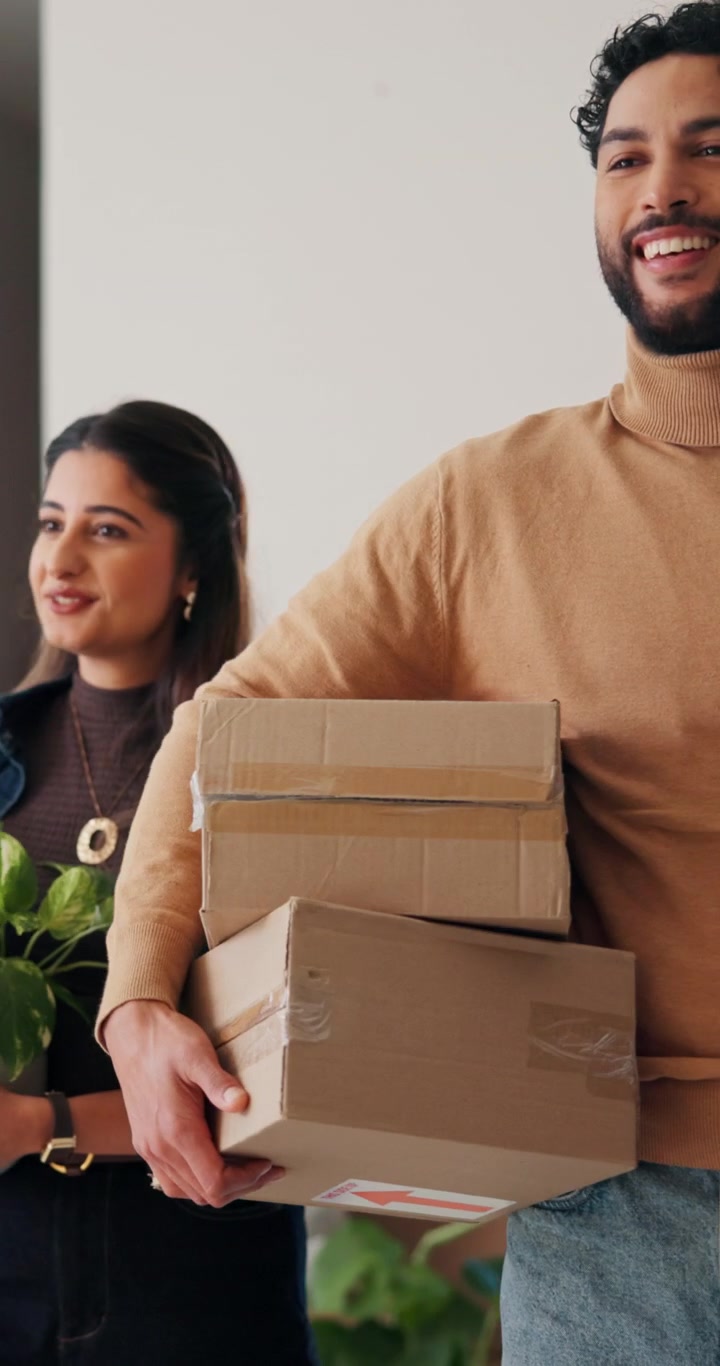 Happy Couple Carrying Moving Boxes into Their New Home