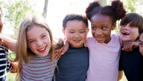 portrait of group of children with friends in park shot in slow motion