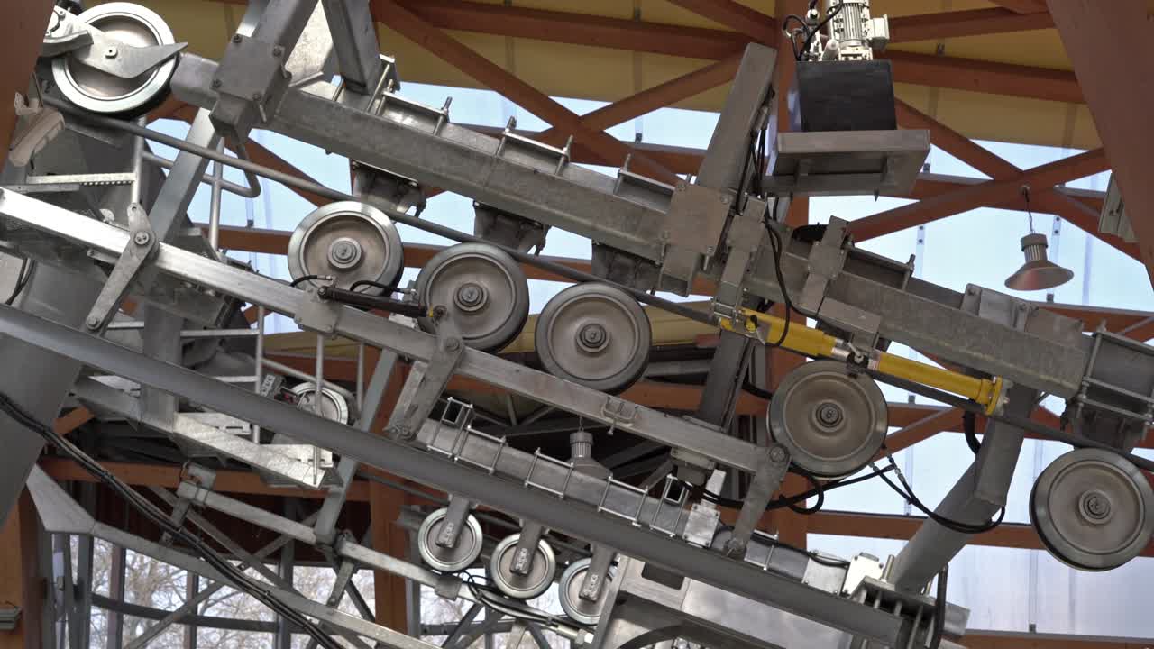 회전하는 바를 가진 금속 후니컬 메커니즘. 산으로 엘리베이터를 들어 올리는