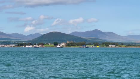 Sailing-Serenity:-Erkunden-Sie-Greencastle-An-Einem-Sonnigen-Tag-Mit-Schiffen-Und-Segelbooten-Vor-Der-Atemberaubenden-Kulisse-Der-Mourne-Mountains-Und-Der-Küstenlandschaft