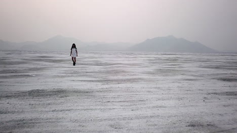 Antena-Dramática-De-Mujer-Caminando-En-Vestido-En-Utah-Desert-Salt-Flat