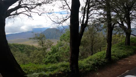 the perspective of a person looking at the view of mount bromo from the top of a moving car