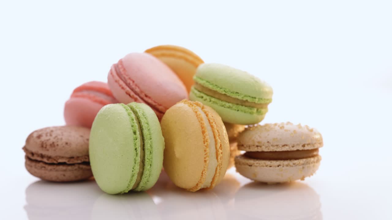 primer plano de las galletas de macarrones multicolores rotación. macarons multicolores, macarrones franceses, pasteles codiciosos. concepto de comida de alta calidad 4k imágenes