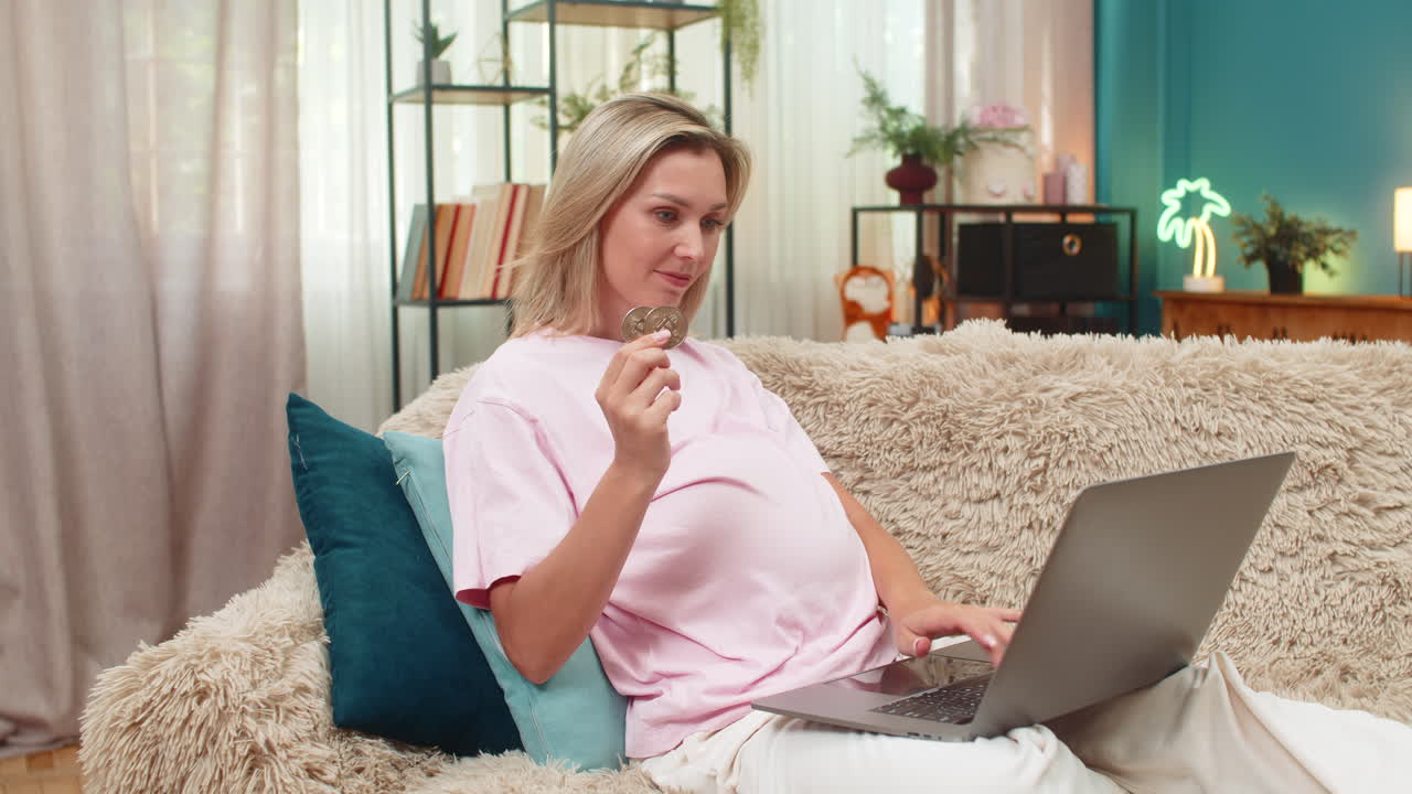 Donna incinta che sorride al laptop mentre il valore dei bitcoin sale, sognando ricchezza e successo grazie al trading da freelance