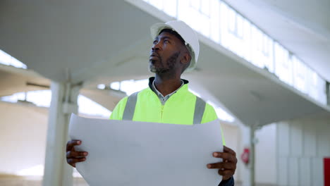 construction worker inspecting building blueprints