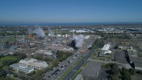 aerial shot of smoke stacks at industrial plant billowing smoke