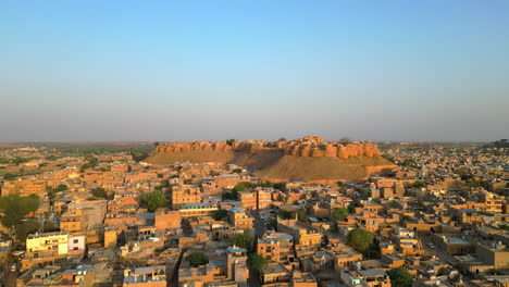 orbit drone shot of the magnificent jaisalmer fort, surrounded by traditional houses showcasing the vibrant charm of rajasthan's desert city india 4k